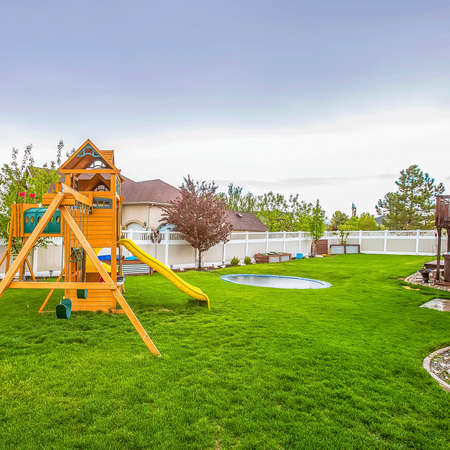 Frame Square Playground equipment and small pool at the spacious backyard of a house