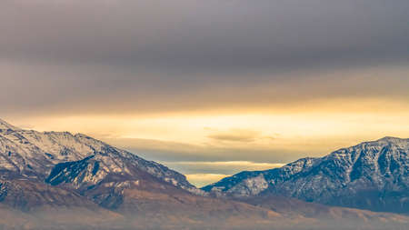 Panorama frame Panorama of a majestic mountain covered with snow and illuminated by sunlightの写真素材