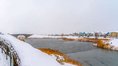 Panorama frame Winding trail with metal guardails overlooking a lake with an arched bridgeの写真素材