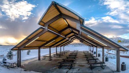 Panorama frame Pavilion and playground at a snow covered park during a frosty winter seasonの写真素材