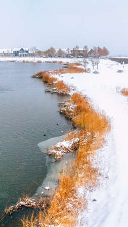 Panorama Snowy bridge overlooking a calm silvery lake amid a frosty landscape in winter