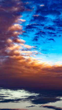 Panorama frame Defocussed view of a vast blue sky filled with puffy dark clouds at sunset