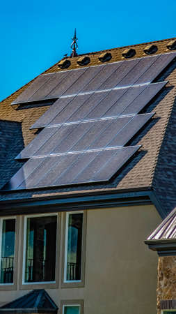 Panorama Solar panels on the dark gray roof with blue sky background on a sunny dayの写真素材