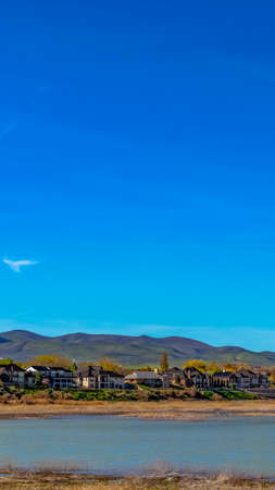 Panorama Panorama of beautiful houses in front of a lake that reflects the blue skyの写真素材