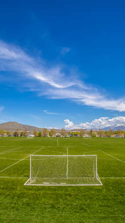 Panorama Soccer field with scenic view of towering mountain and vibrant blue skyの写真素材