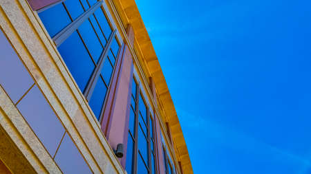 Panorama Commercial building exterior with cylindrical wall lights and blue windows