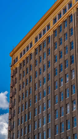 Panorama Exterior of a building with the cloudy blue sky reflected on the glass windowsの写真素材