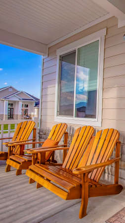 Panorama frame Brown wooden chairs in front of a window at the sunlit porch of a houseの写真素材