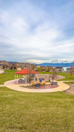 Panorama Park and playground amid lush green lawn and lovely homes near a lakeの写真素材