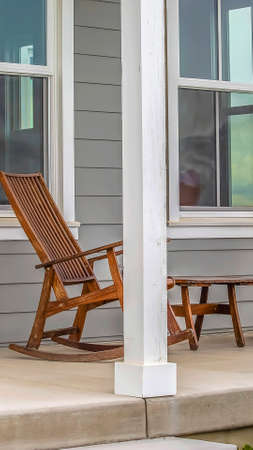Panorama Front porch of a house with brown rocking chairs and rectangular white pillarsの写真素材