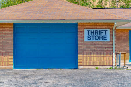 Building with pitched roof and large blue door viewed on a sunny dayの写真素材