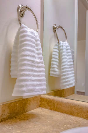Bathroom interior with close up view of a white towel hanging on a towel ringの写真素材