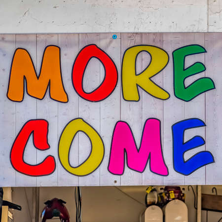 Square frame Sign at the entrance of a building that reads More Inside Come On Inの写真素材