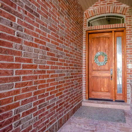 Square frame Rustic wooden door with wreath sidelight and arched transom windowの写真素材