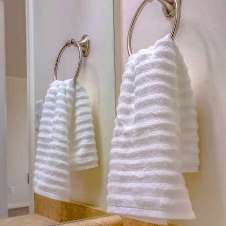 Square Bathroom interior with close up view of a white towel hanging on a towel ringの写真素材
