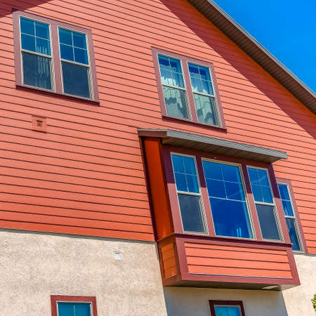 Square frame Exterior of home with a combination of red wood section and neutral wallの写真素材