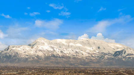Panorama Houses and buildings on a vast valley under bright blue sky with clouds
