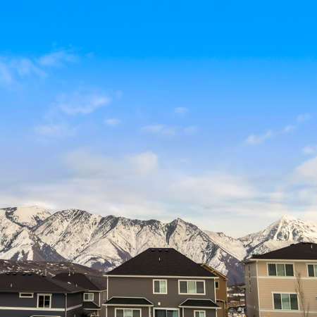 Square frame Exterior view of houses with mountain peak covered with snow in the background