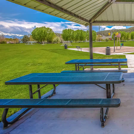 Square frame Outdoor eating area inside a pavilion surrounded by lush grasses and treesの写真素材
