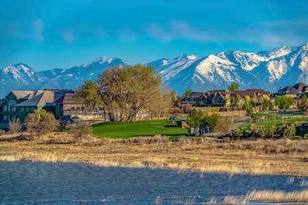 Rippling blue lake with houses and road in front of the grassy shoreの写真素材
