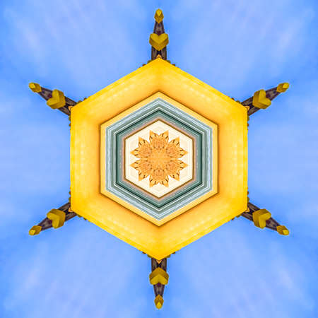 Yellow facade of the decorative building on side. Geometric kaleidoscope pattern on mirrored axis of...