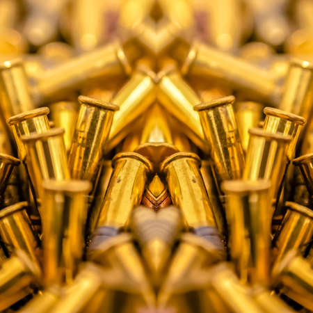 Pile of bullets on an axis of symmetry. Geometric kaleidoscope pattern on mirrored axis of symmetry reflection. Colorful shapes as a wallpaper for advertising background or backdrop.の写真素材