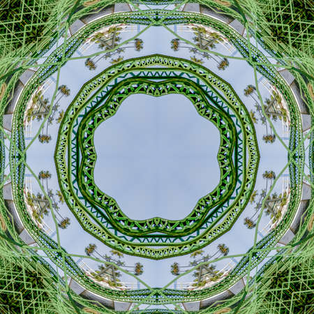 Circular green metal bars created using reflections in a rounded shape from a bridge in California with copy space. Geometric kaleidoscope pattern on mirrored axis of symmetry reflection. Colorful shapes as a wallpaper for advertising background or backdrop.の写真素材