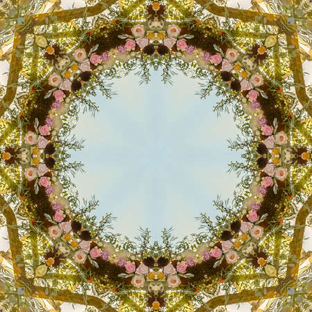 Circular angular floral design made from wedding flowers at sunset. Geometric kaleidoscope pattern on mirrored axis of symmetry reflection. Colorful shapes as a wallpaper for advertising background or backdrop.の写真素材
