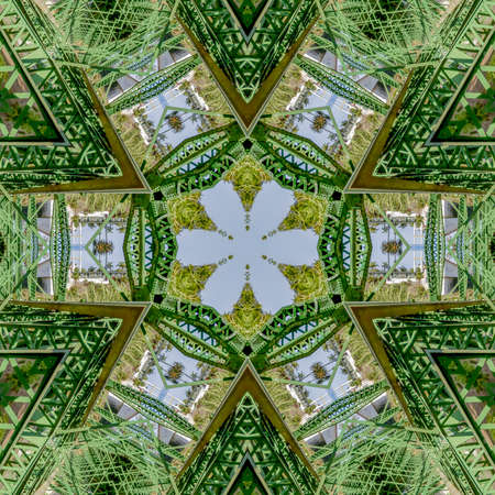 Patterned photo created from the shapes of a green bridge in California. Geometric kaleidoscope pattern on mirrored axis of symmetry reflection. Colorful shapes as a wallpaper for advertising background or backdrop.の写真素材