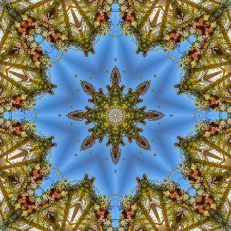 Vivid shapes with angular displays of flowers in circular arrangement at wedding in California. Geometric kaleidoscope pattern on mirrored axis of symmetry reflection. Colorful shapes as a wallpaper for advertising background or backdrop.の写真素材