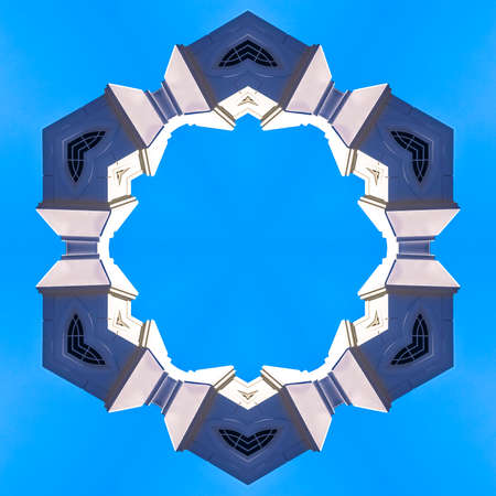 Church steeple formed into an angular ring. Geometric kaleidoscope pattern on mirrored axis of symmetry reflection. Colorful shapes as a wallpaper for advertising background or backdrop.の写真素材