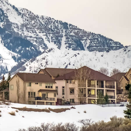 Square Neighborhood built on a hill overlooking a striking snowy mountain in winterの写真素材