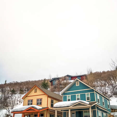 Square frame Facade of mountain homes with horizontal siding and balconies against cloudy skyの写真素材
