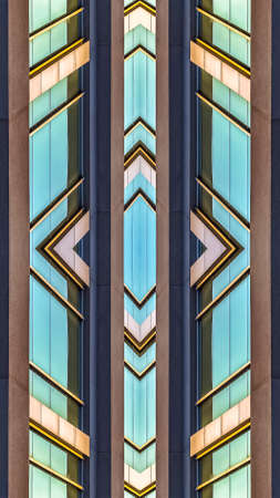 Vertical frame Shiny teal windows of an office building. Geometric kaleidoscope pattern on mirrored...