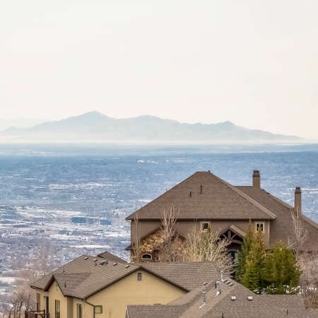 Square frame Rooftops of homes with cloudy sky mountain and vast valley in the background. Vivid...