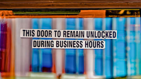 Panorama Sign that reads This Door To Remain Unlocked During Business Hours. Reflection of buildings...