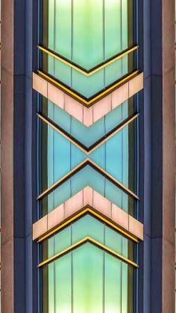 Vertical Shiny windows of office building downtown. Geometric kaleidoscope pattern on mirrored axis of symmetry reflection. Colorful shapes as a wallpaper for advertising background or backdrop.の写真素材