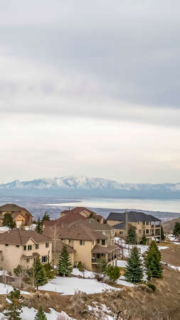 Vertical Residential area on a hill with view of lake valley and mountain in winterの写真素材