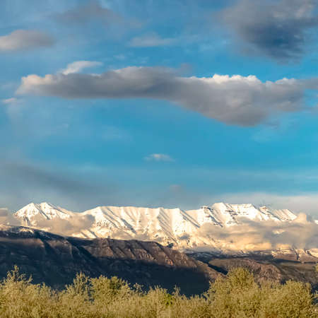 Square Scenic nature view with majestic snow peaked mountain under cloudy blue skyの写真素材