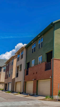 Vertical frame Homes with wood concrete and brick exterior walls against mountain and blue sky