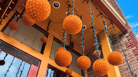 Panorama Orange light balls hanging at the entrance of a building with red brick wallの写真素材