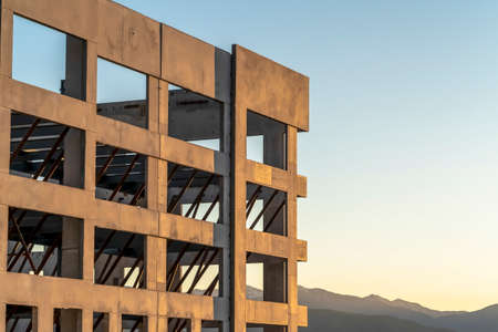 Close up of an unfinished building exterior with mountain and sky background