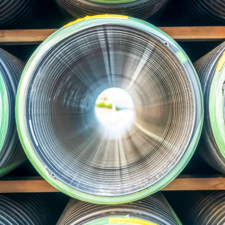Square frame Close up of the holes of shiny metal pipes on a sunny dayの写真素材