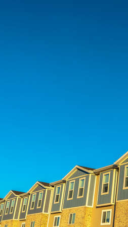 Vertical frame Facade of townhouses with clear blue sky background on a sunny day