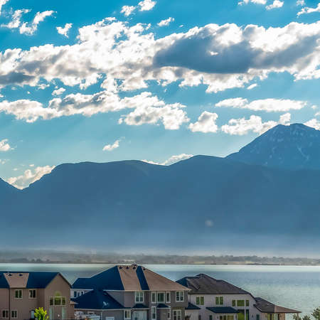 Square Residential area with scenic view of lake and mountain under cloudy blue sky