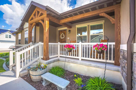 Garden stairs porch and arched entryway at the facade of a home on a sunny day