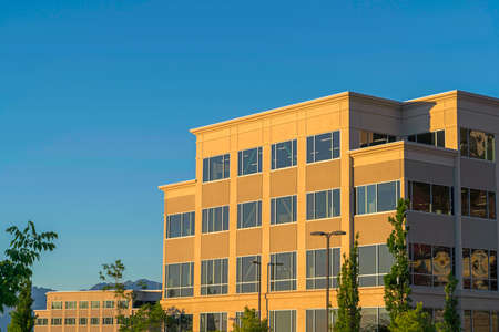 Commercial modern building exterior viewed against blue sky on a sunny dayの写真素材