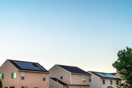 Homes with white horizontal siding on wall and solar panels on the rooftopsの写真素材