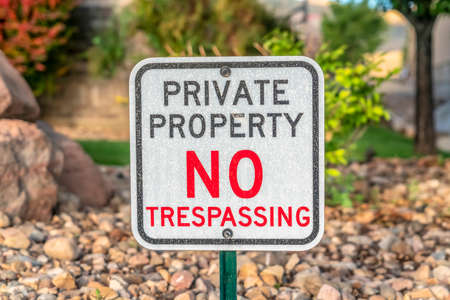 Private Property No Trespassing sign with rocky terrain and trees backgroundの写真素材