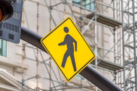 Close up view of a yellow and black diamond shaped Pedestrian Crossing signの写真素材
